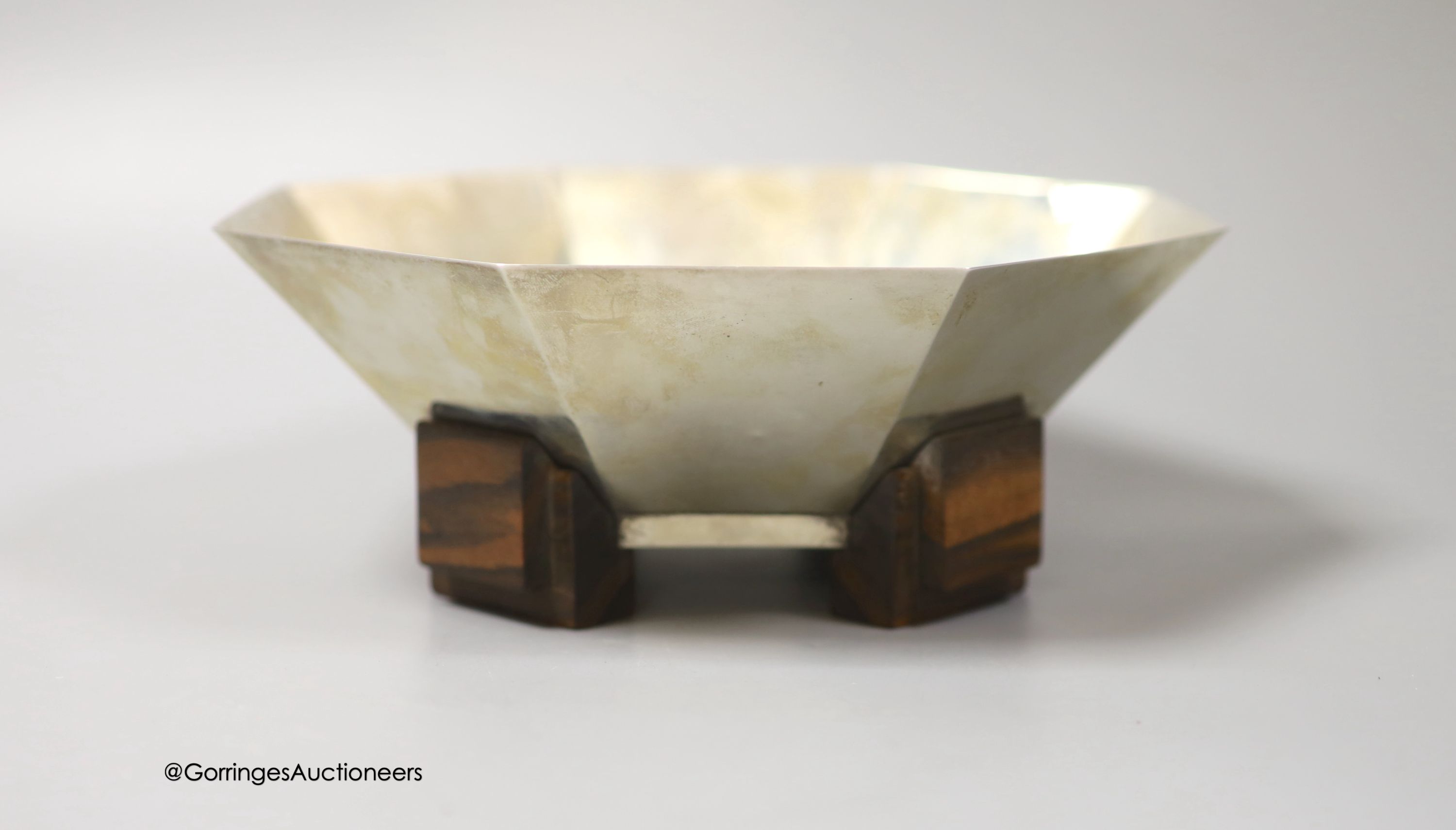 A German? Art Deco 800 standard white metal octagonal fruit bowl, on four stepped coromandel wood feet, indistinct maker's mark, diameter 22.2cm, gross weight 18oz.